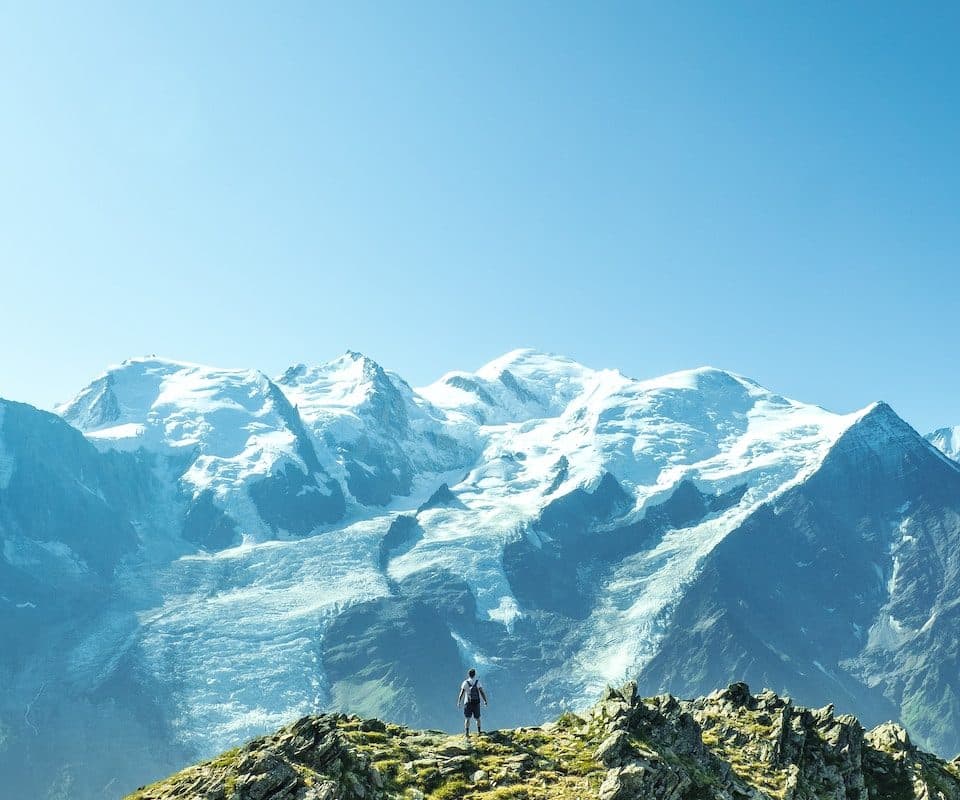 man standing overlooking mountain at daytime
