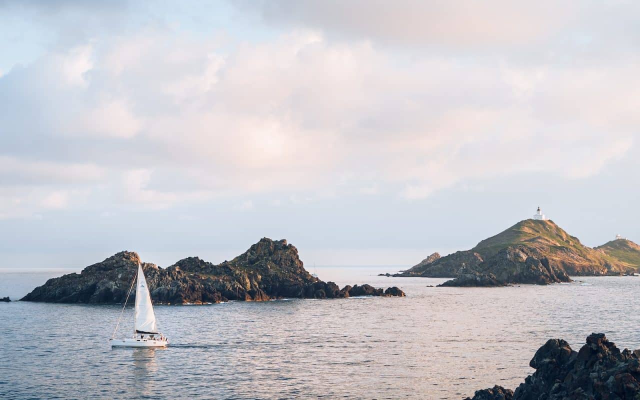 a sailboat in a body of water near a small island